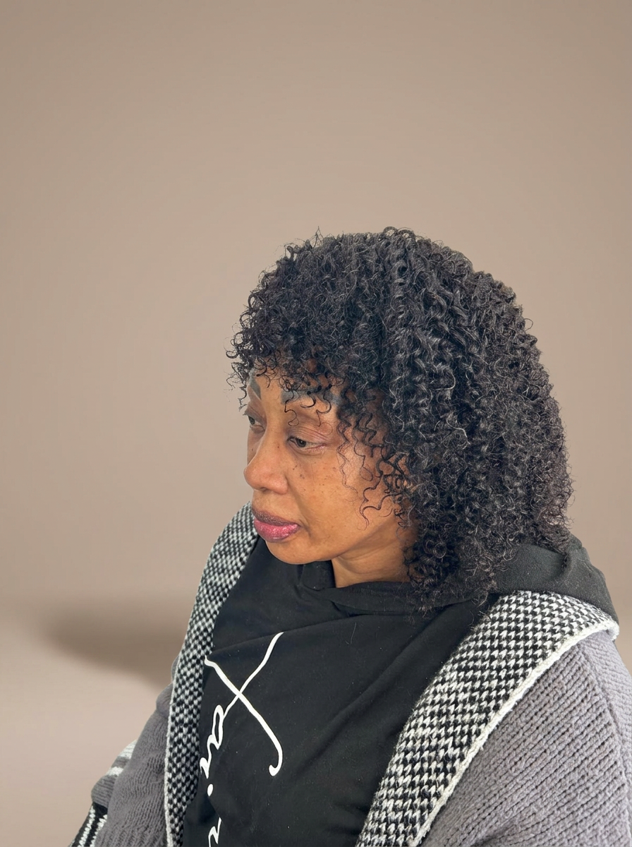 Shoulder-length curly crochet hairstyle with fringe, styled at Dixa Hair & Beauty Salon